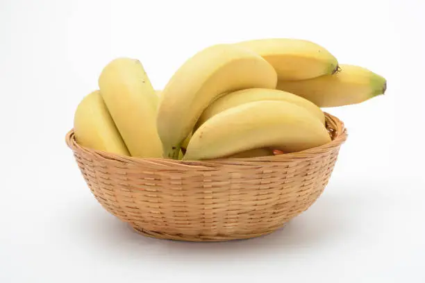 Bananas in a wicker basket on white background