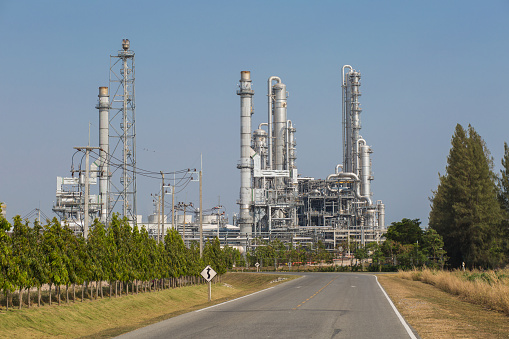 Landscape view of street road and oil refinery plant with blue sky