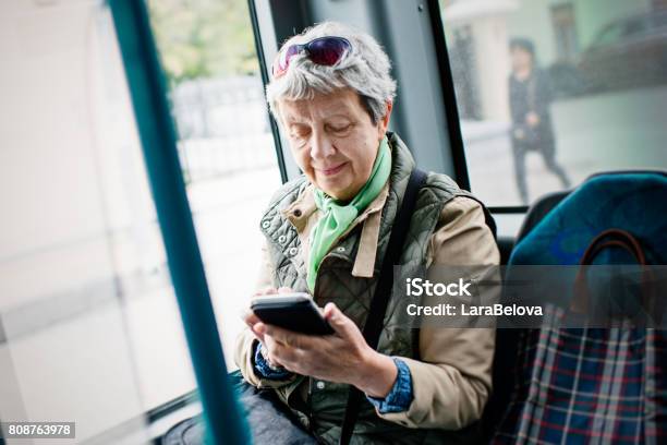 Senior Woman Using Smartphone In The Bus Stock Photo - Download Image Now - Bus, Senior Adult, Telephone