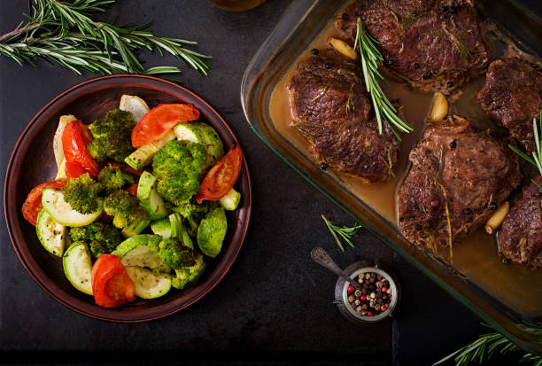 Baked beef steak with garlic and rosemary and vegetables. Flat lay. Top view