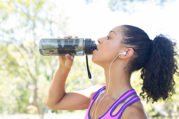 istock Close-up of female jogger drinking water 808773986