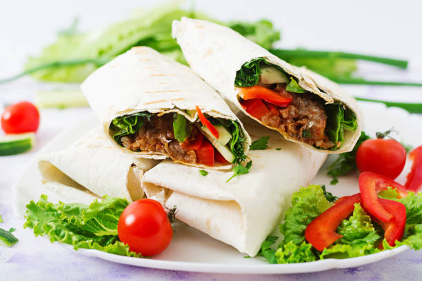 istock Burritos wraps with minced beef and vegetables on a light background. 808774024