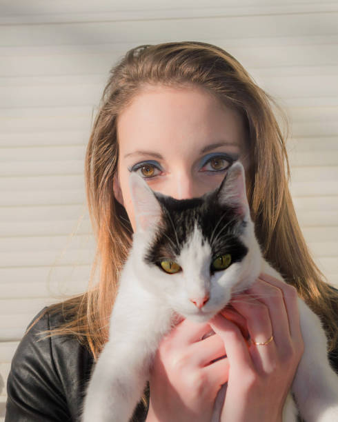 istock Woman hides behind the cat 808778658