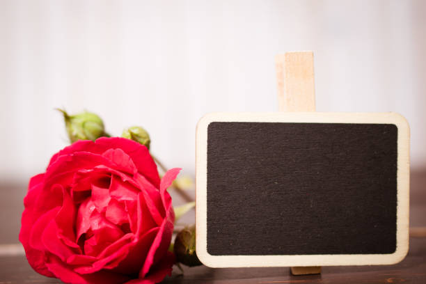 flowers with chalkboard on wooden table with copy space and celebration concept