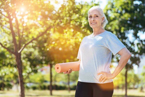 istock Cheerful aged woman practicing yoga outdoors 808809734