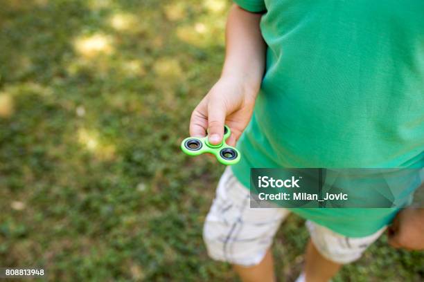 Child Having Fun Outdoors With Fidget Spinner Stock Photo - Download Image Now - 2017, Cheerful, Child