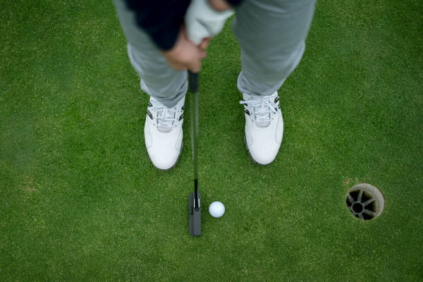 istock Close-up on a man playing golf hitting the ball into the hole 808828670