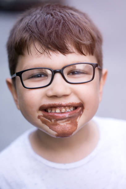 fröhlicher junge mit brille und eis - child chocolate ice cream human mouth stock-fotos und bilder