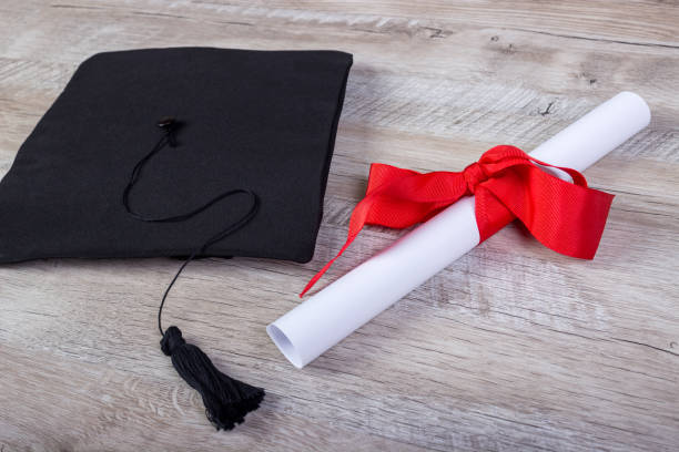 istock graduation cap, hat with degree paper on wood table graduation concept 808970494
