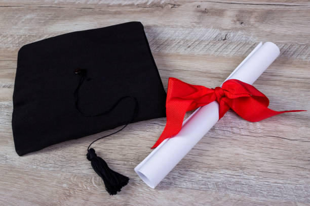 istock graduation cap, hat with degree paper on wood table graduation concept 808970514