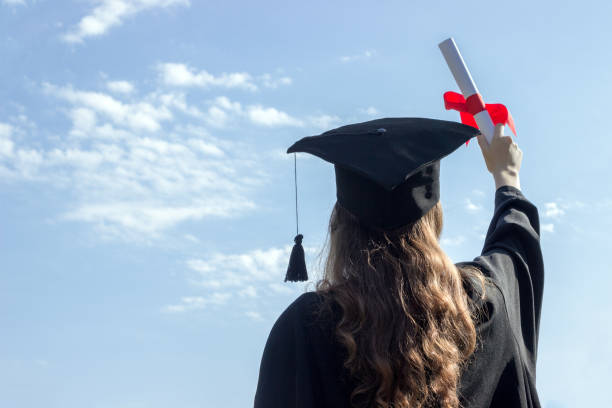 istock Graduate put her hands up and celebrating with certificate in her hand and feeling so happiness in Commencement day. Toned 808970570
