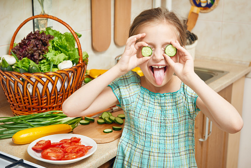 girl in kitchen interior, vegetables and fresh fruits in basket, healthy nutrition concept