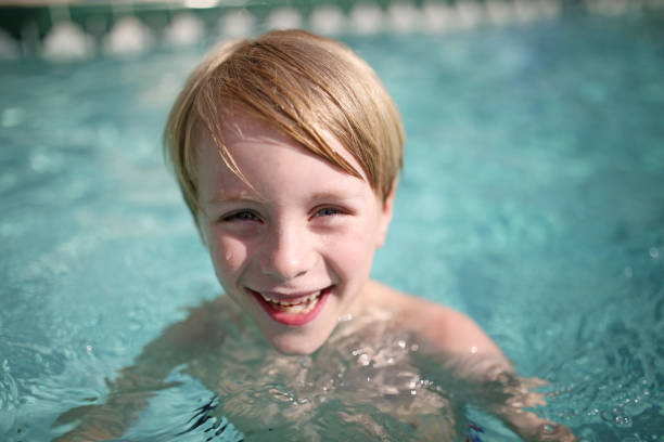 istock Happy Young Child Laughing in Swimming Pool 809056528