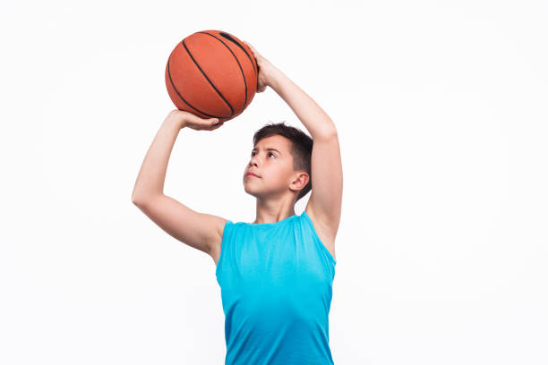 istock Young boy playing basketball isolated on white 809056716