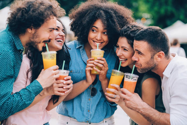 Group of friends drinking smoothies Group of friends drinking juice outdoors in the city juice drink stock pictures, royalty-free photos & images