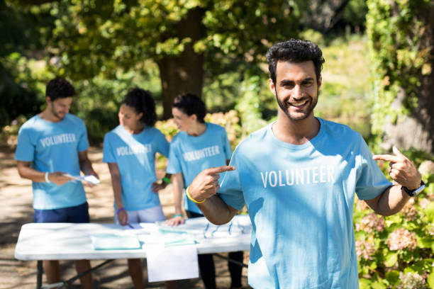 istock Smiling volunteer pointing at his t-shirt 809065186