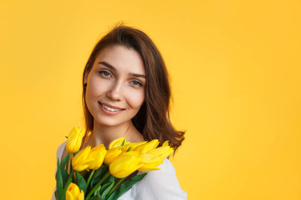 istock Gentle girl with yellow tulips 809071486