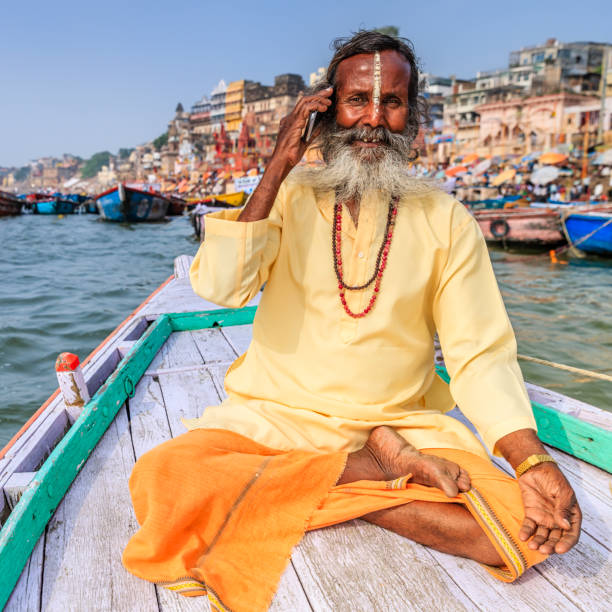 istock Sadhu using mobile in boat on Holy Ganges River, Varanasi 809075888