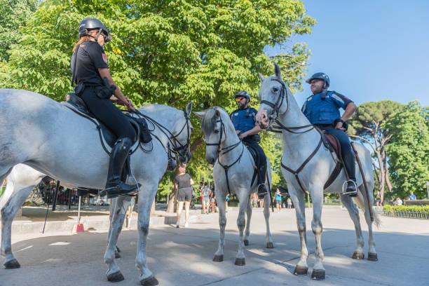 Mounted Police Four police officers riding white horses on duty at Parque del Retiro in Madrid, Spain police policewoman women spain stock pictures, royalty-free photos & images
