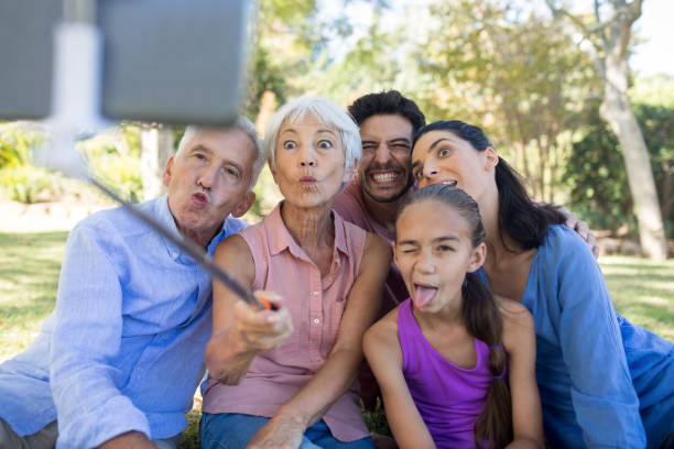 istock Family making funny faces while taking a selfie in the park 809086302