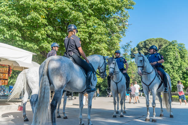 Mounted Police Four police officers riding white horses on duty at Parque del Retiro in Madrid, Spain police policewoman women spain stock pictures, royalty-free photos & images