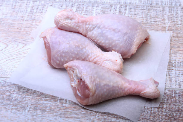 istock raw chicken legs with spices on a wooden board. Ready for cooking. 809098224