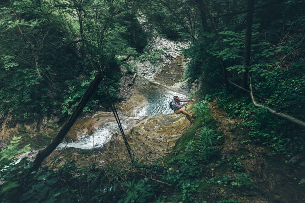 istock Hiker Traveler Explorer Climbs The Hill On Waterfall Background Support Exercise Extreme Sports Concept 809105642