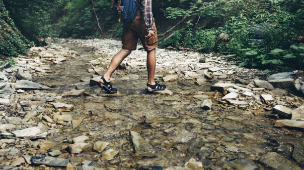 istock Unrecognizable Tourist With Backpack Crosses Wild River Into ford. Trek Hiking Destination Experience Lifestyle Concept 809105852