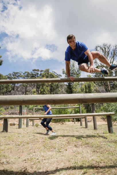 istock Man and woman jumping over the hurdles during obstacle course 809108342