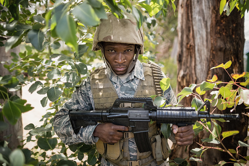 Portrait of confident military soldier guarding with a rifle in boot camp