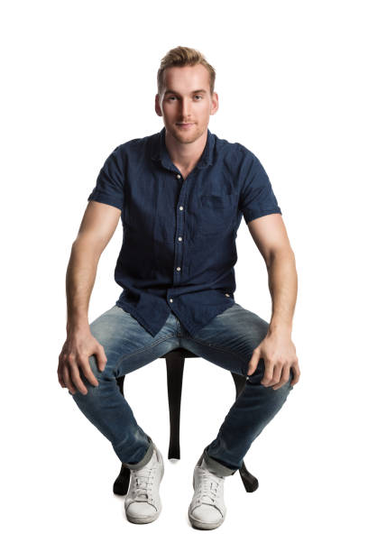 istock Man in blue shirt and jeans sitting down 809208592