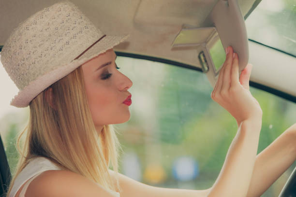 istock Distracted woman driving her car looking in mirror 809245286