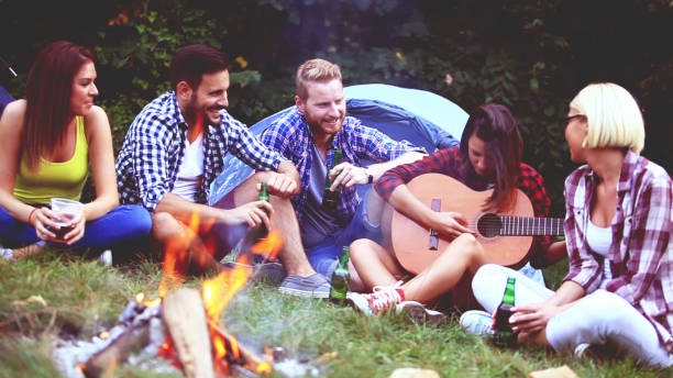 istock Five friends sitting next to campfire and singing song 809289066