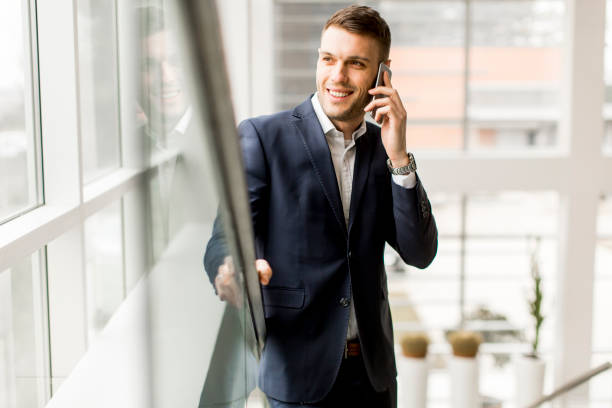 istock Handsome businessman talking on mobile phone while standing on the stairs 809350850