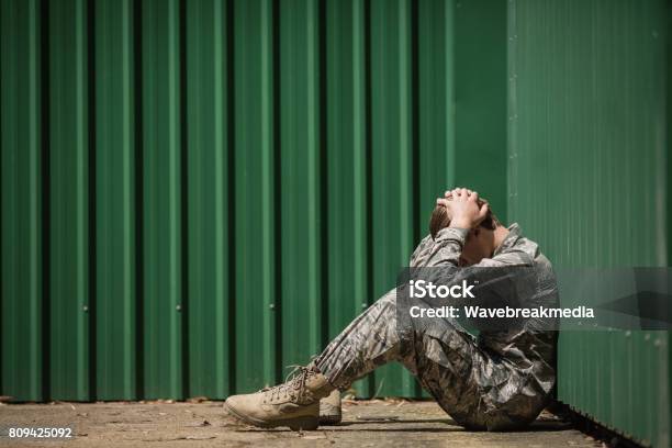 Frustrated Military Soldier Sitting With Hands On Head Stock Photo - Download Image Now