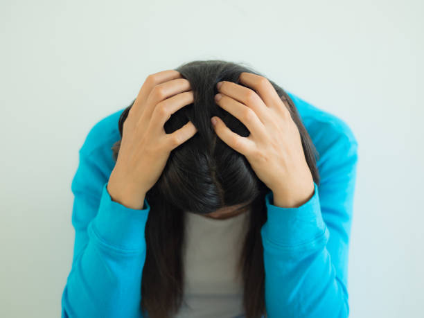 istock A woman deep in thought or with a headache, against a dark background room for copyspace 809425986