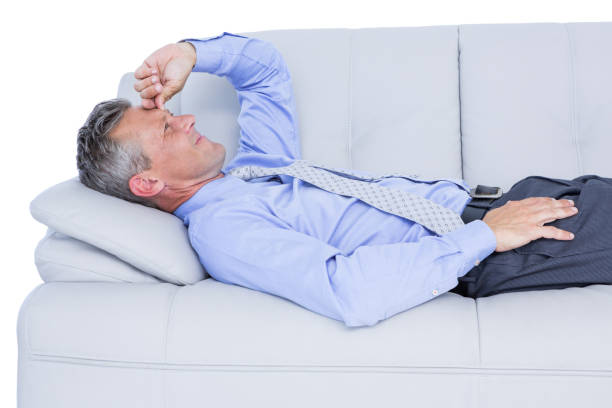 istock Tired businessman lying on the sofa 809577924