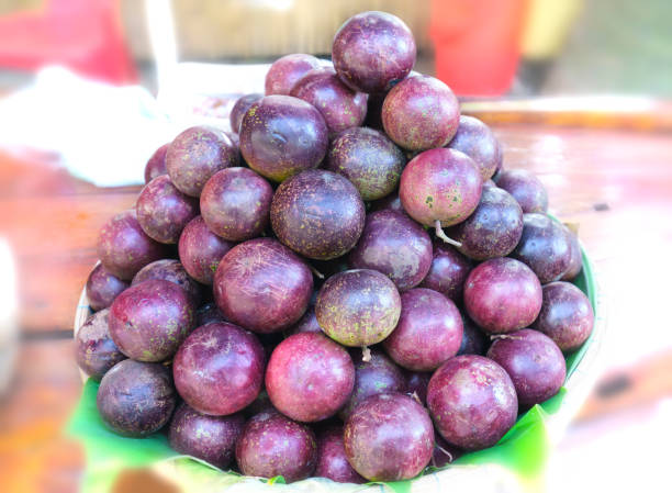 Ripe purple star apple fruit is stacked for sale to consumers Ripe purple star apple fruit is stacked for sale to consumers chrysophyllum cainito stock pictures, royalty-free photos & images
