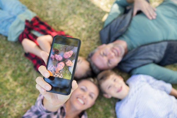 istock Happy family lying on the grass and taking selfie 809611918