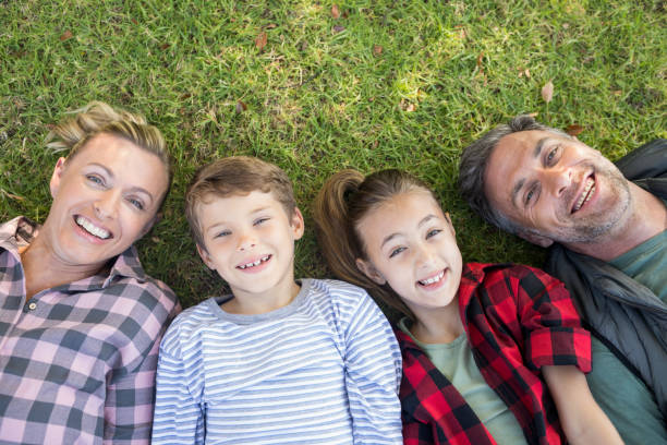 istock Happy family lying on the grass in park 809615234