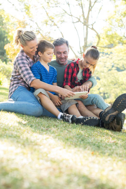 istock Family using digital tablet in the park 809637228