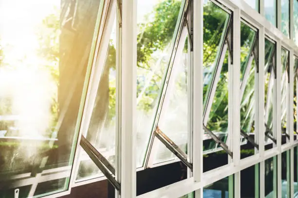 Photo of Modern office building wall and opened window in the morning, with bright sunlight