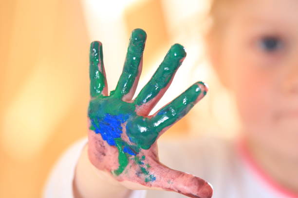 istock Kid hand in green paint close-up 809723980
