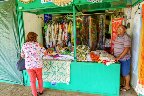 Brasilia, Brazil - February 28, 2017: Working in Brazil businesses theme. Stallholder and customer inside market stall selling souvenirs