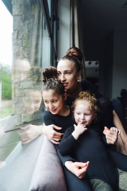 istock Mom and two daughters together at the window 809784982