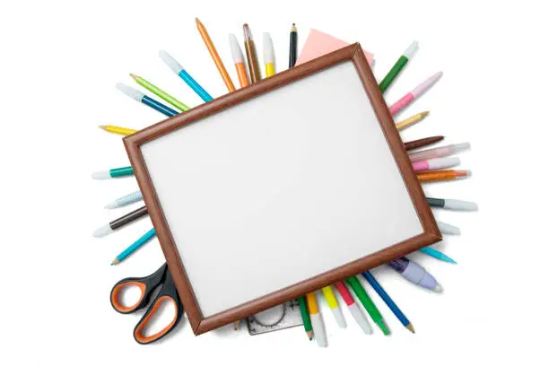 High angle view of a blank frame over school supplies, isolated on white background