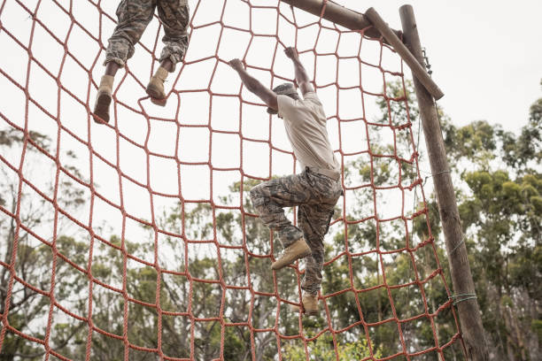 istock Military soldiers climbing a net during obstacle course 809811216
