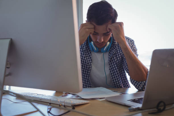 istock Confused graphic designer sitting in office 809812250