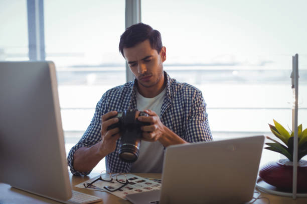 istock Photographer with camera working in ofice 809817262