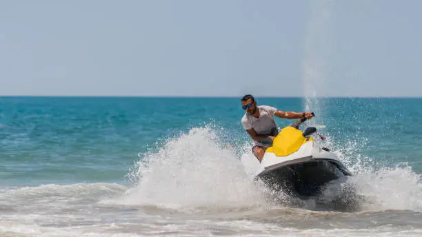 Young men cruising the caribbean sea on a jet ski